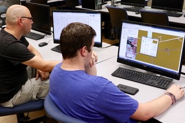 Scott Moranda and Devyn Tremblay work on computers.